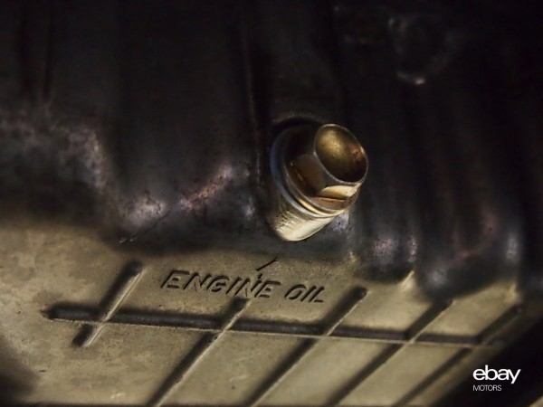 Find the oil drain plug located under the car