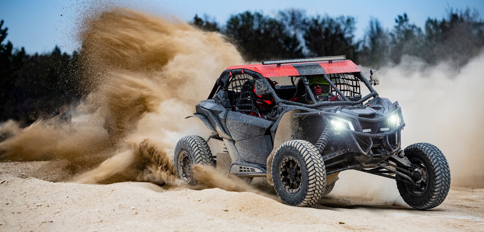 UTV in the sand throwing a rooster tail